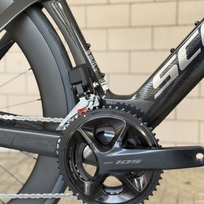 Quadro de bicicleta de carbono preto detalhe com roda aerodinâmica e sistema Shimano 105