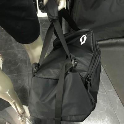Mochila preta com alças sendo segurada por um manequim com shorts pretos
