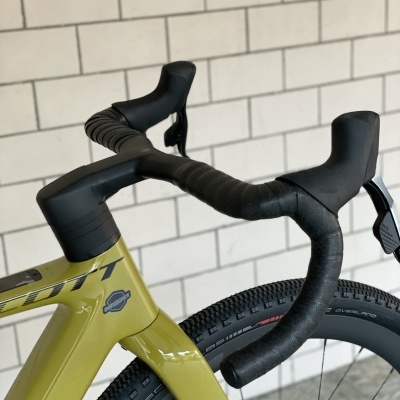 Bicicleta verde-oliva com guiador curvo preto e pneus pretos com textura