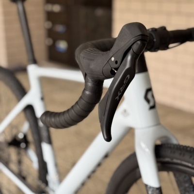 Bicicleta branca com guiador preto e manete GRX