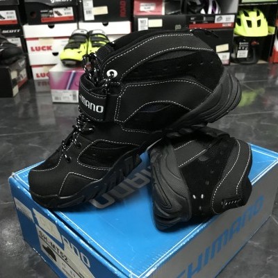 Botas de caminhada pretas Shimano com detalhes brancos sobre caixa azul em loja