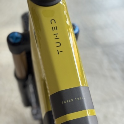 Quadro de bicicleta amarelo e preto com texto TUNED e SUPER TRAIL