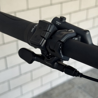 Manípulo e punho de bicicleta negro com botões e texto SHIMANO LV OIL