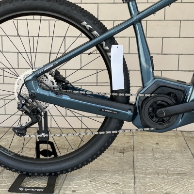 Parte traseira de uma bicicleta elétrica azul-acinzentada com motor Bosch e texto SCOTT amarelo