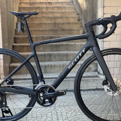 Bicicleta de estrada carbono preta com logo SCOTT e componentes Shimano