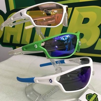 Três óculos de sol desportivos com lentes coloridas em suporte transparente