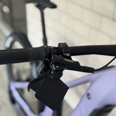 Guiador com punho e manete Shimano numa bicicleta lilás