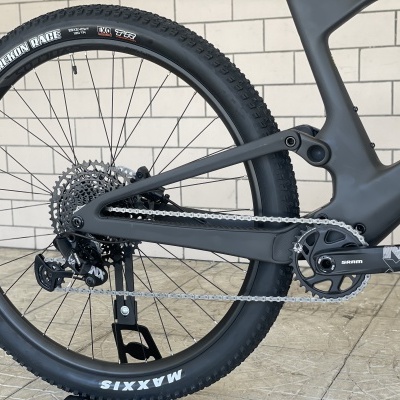 Roda traseira de bicicleta com pneu preto MAXXIS e quadro cinzento escuro com detalhes amarelos