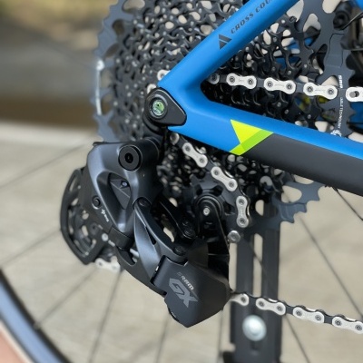 Traseira de bicicleta azul com desviador Shimano SLX e corrente em pavimento exterior