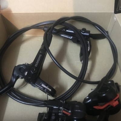 Conjunto de travões hidráulicos pretos Shimano para bicicleta numa caixa de cartão