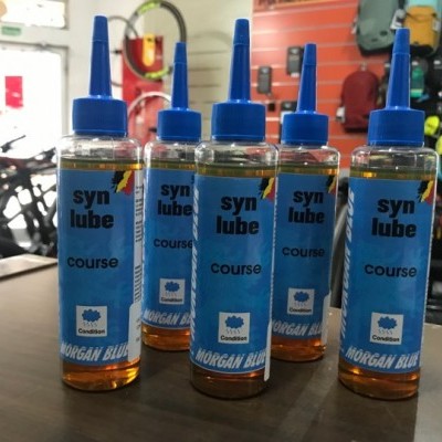 Frascos de óleo lubrificante azul com tampa azul numa loja de bicicletas