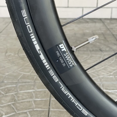 Roda de bicicleta preta com aro DT Swiss e pneu Schwalbe One