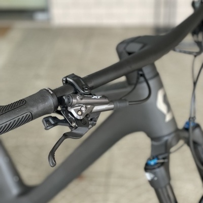 Guiador de bicicleta cinza com componentes em metal e punho preto