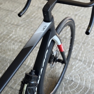 Bicicleta de estrada preta e cinza com garrafa COLNAGO e texto V4RS no quadro