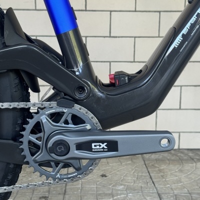 Quadro preto e azul de bicicleta com pedaleira e corrente metálica e selo GX SRAM