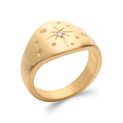 Anel dourado com gravações de estrelas e pedra branca.