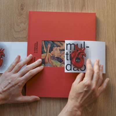 Livro vermelho com pequeno livreto aberto mostrando um coração anatômico desenhado