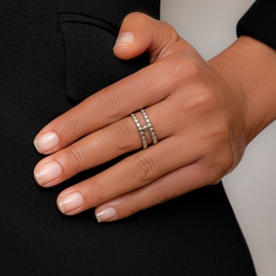 Mão com anel prateado em casaco preto