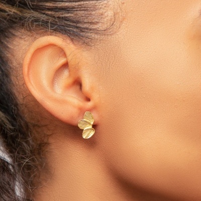 Brincos dourados de três folhas curvas na orelha