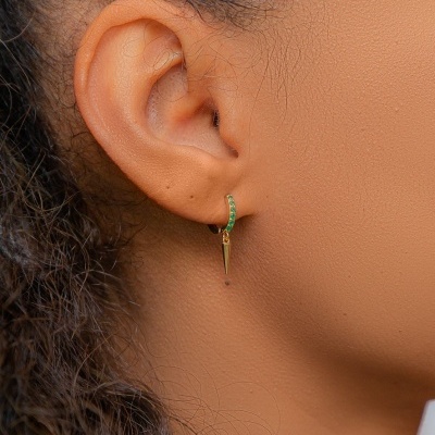 Brinco dourado com pedras verdes e pendente cónico na orelha