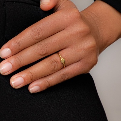 Mão com anel dourado fino e roupa preta