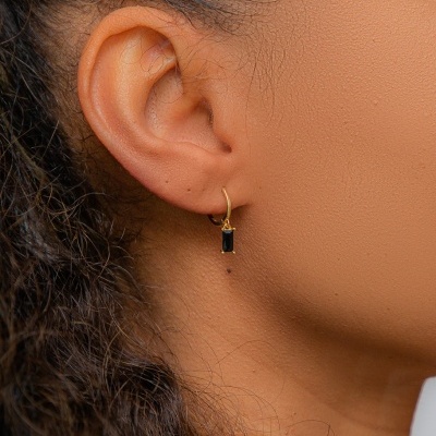 Brinco dourado com pedra preta retangular na orelha