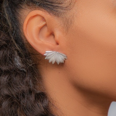 Brinco prateado em forma de folha na orelha