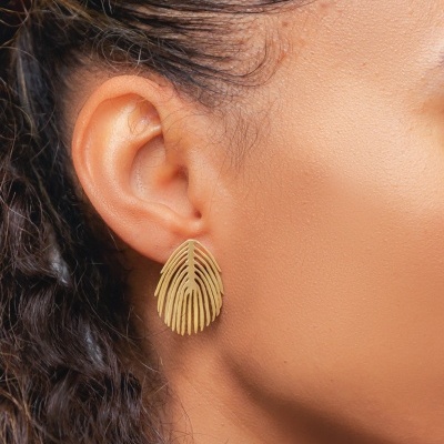 Brinco dourado em forma de folha com padrão recortado na orelha