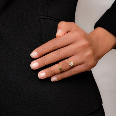 Mão feminina com two anéis dourados e blazer preto