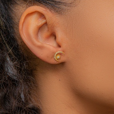 Brinco dourado em forma de meia-lua com sol na orelha