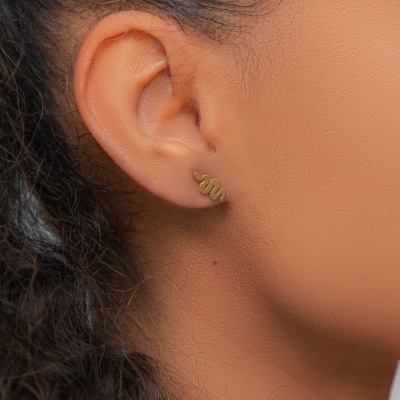 Brinco dourado em forma de serpente na orelha de mulher