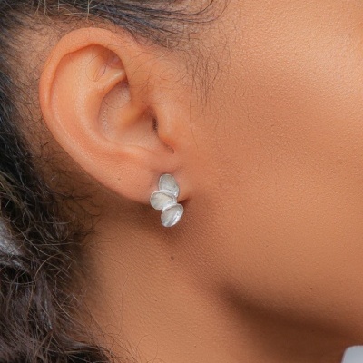 Brinco pequeno em prata com design de três folhas na orelha