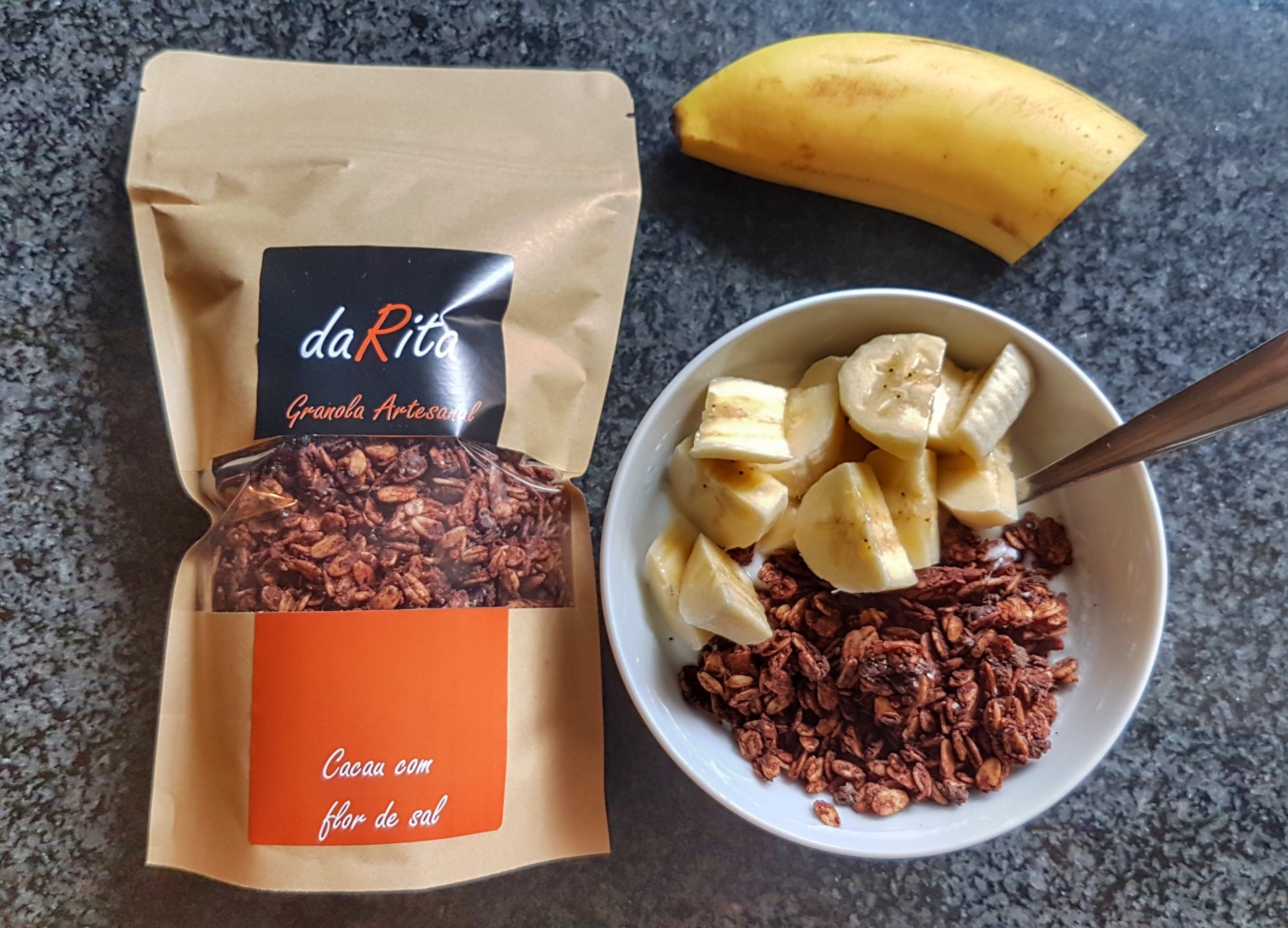 Pacote de granola artesanal daRita com tigela de granola e banana