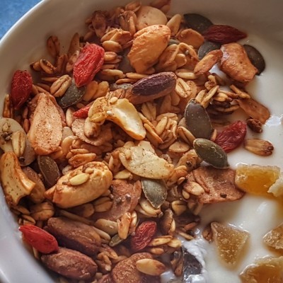 Granola com frutos secos e sementes sobre iogurte branco