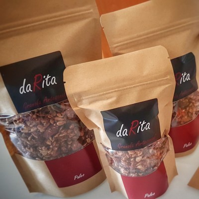 Embalagens de granola daRita em papel castanho com janela transparente e rótulos pretos e vermelhos