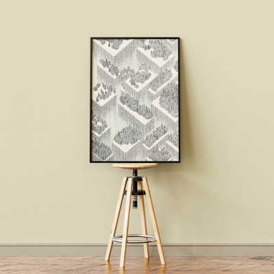 Moldura com padrão geométrico preto e cinzento sobre banco de madeira num chão e parede claros.