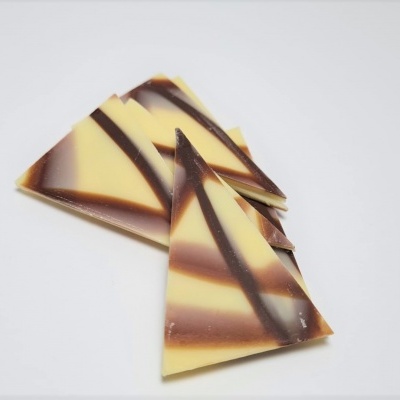 Pedras marmoreadas de chocolate em vários tons de castanho e bege sobre fundo branco