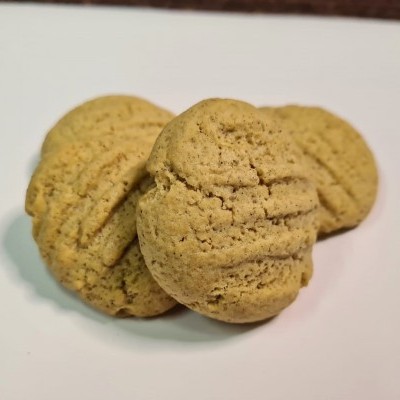 Três bolachas redondas bege claro com textura quebradiça sobre superfície branca