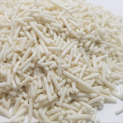 Peças cilíndricas brancas em amontoado sobre superfície branca