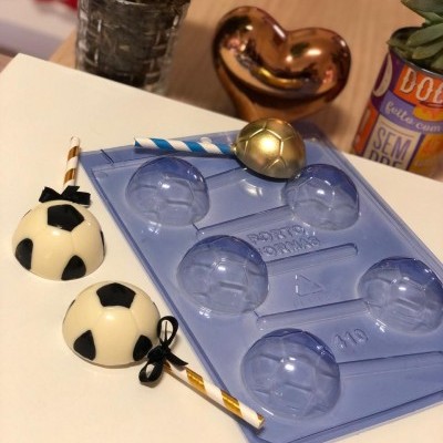 Forma de plástico azul para bolas de futebol com bombocas e palhinhas e plantas de decoração