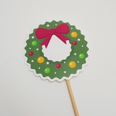 Decoração de Natal em forma de coroa verde com bolas coloridas e laço vermelho