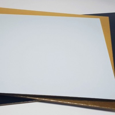 Três folhas quadradas de papel nas cores branco, dourado e azul escuro empilhadas