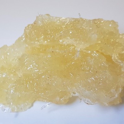 Massa gelatinosa amarela translúcida sobre superfície branca