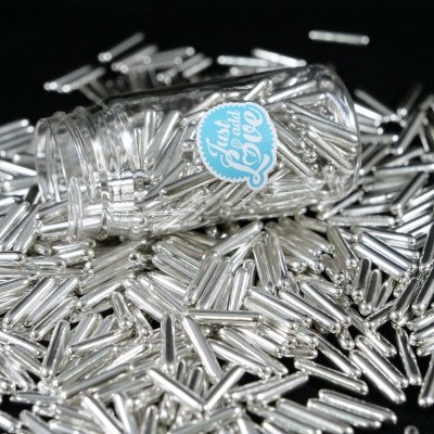 Frasco com pequenos tubos metálicos prateados espalhados em fundo preto