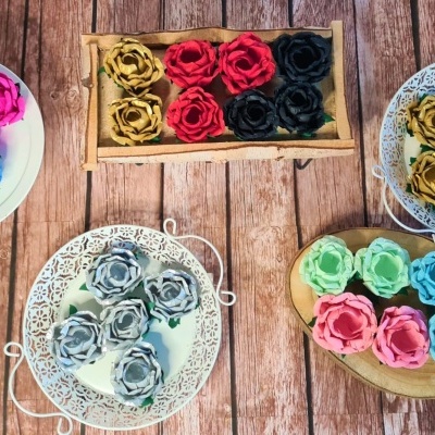 Flores artificiais coloridas em cestos de metal e madeira sobre superfície de madeira