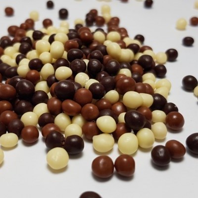 Esferas de chocolate em três cores sobre superfície branca