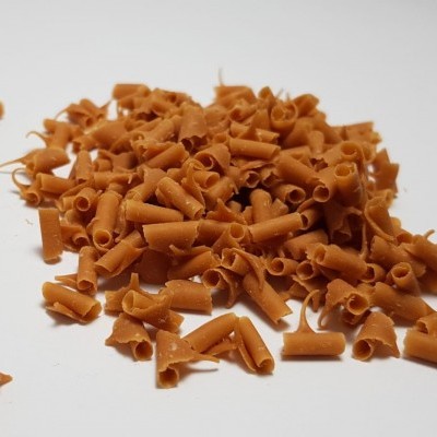 Pequenos pedaços de chocolate castanho sobre superfície branca