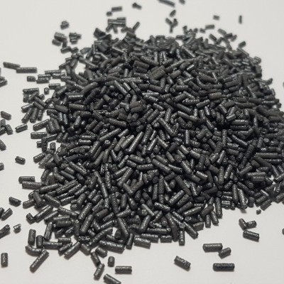 Pequenos pellets pretos espalhados sobre fundo branco