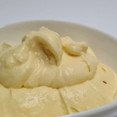 Tigela branca com creme amarelo claro e textura cremosa