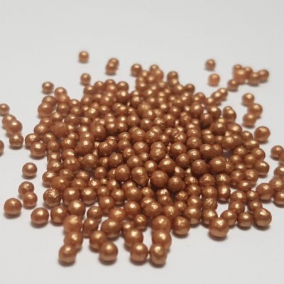 Pérolas ou contas bronzeadas redondas sobre fundo branco